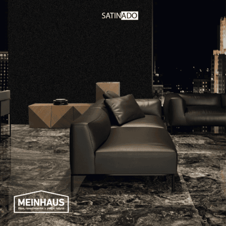 Sofá de cuero negro y diseño moderno en un espacio interior minimalista con piso de piedra sinterizada